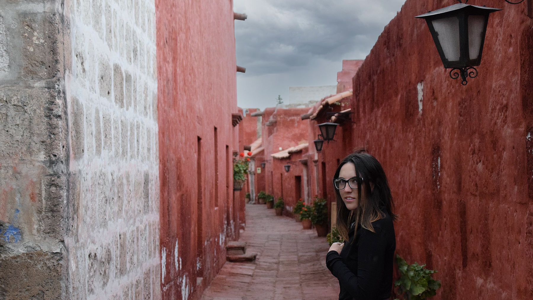 Founder of Splice Reversible Clothing Ashly Ryan looking back at the camera while walking down an alley in Arequipa, Peru